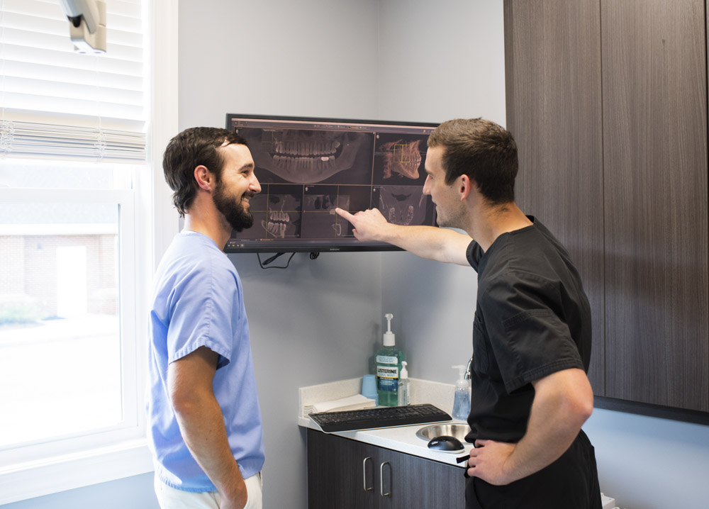 Dr. Jon Byrd and Dr. Preston Ford of High Point Dental Partners standing near screen in exam room
