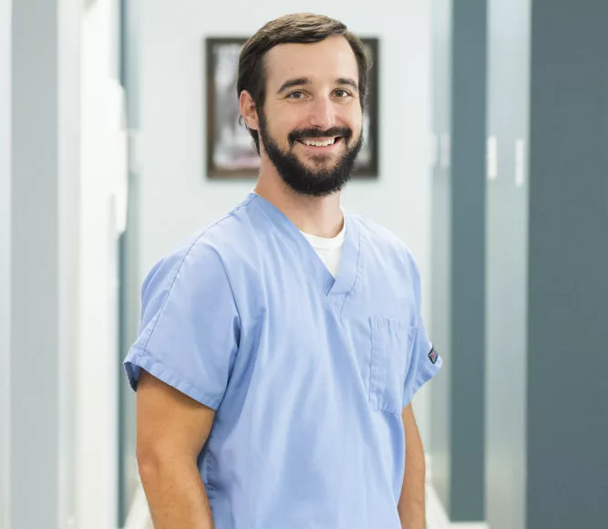 Dr. Jon Byrd of High Point Dental Partners smiling standing in hallway of office
